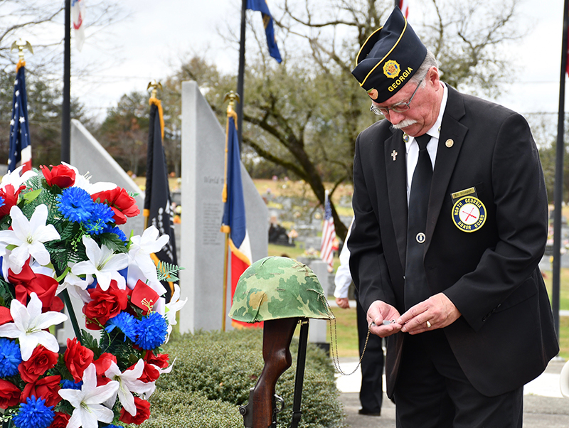 North Georgia Honor Guard Commander Bill Stodghill looks at the dog tags of fallen soldier during Fannin County’s Veterans Day ceremony Saturday, November 7.