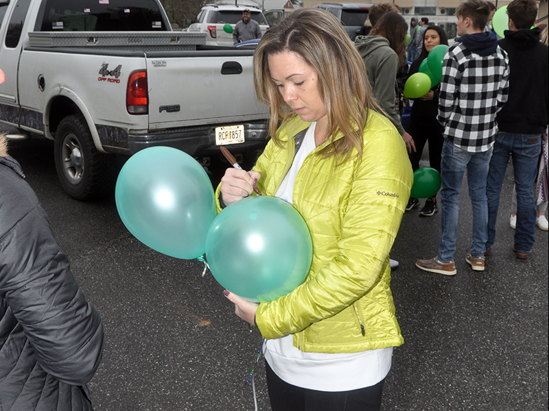 Samantha Bailey writes a message on one of her balloons before they were released Friday, January 22. She was among the many friends and family members of Sydnie Jones who gathered in the parking lot of the First Baptist Church of Blue Ridge to honor Jones' life.