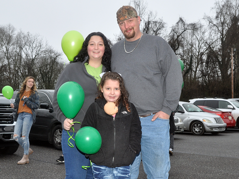 RIGHT: Bristol Cash waits patiently with her parents, Abby and Teddy Cash at the balloon release in the parking lot of First Baptist Church of Blue Ridge Friday, January 22.