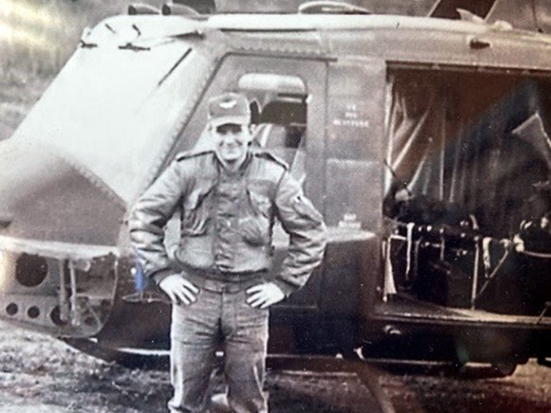 During his time in the Army, Rod McIntyre worked on and flew helicopters, such as the one shown behind him. He spent the majority of his time during the Vietnam War stationed at Camp Holloway.