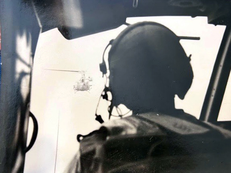 Rod McIntyre flew several missions via helicopter during his service in the Vietnam War. He managed to take a photo, shown above, from behind the pilot of a helicopter as his crew descended into the landing zone using a “daisy chain” technique.
