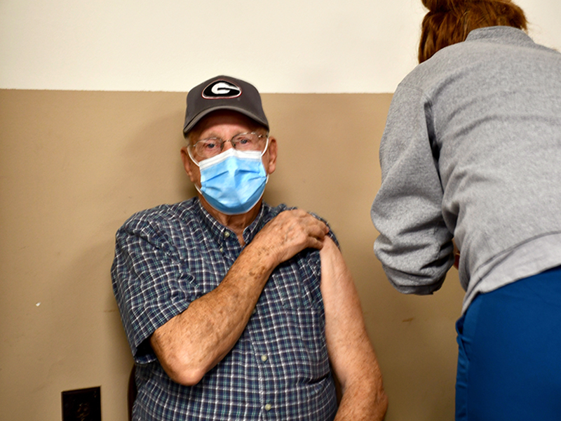 Bob Daves held his shirt sleeve up as he patiently waited to receive his COVID-19 vaccination from Tamra Head with the Fannin County Health Department Monday February 8.