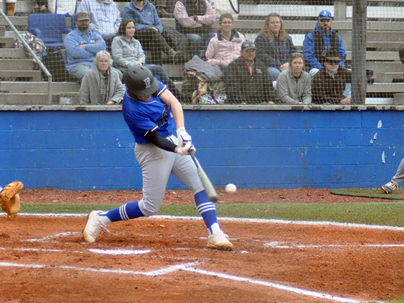 Logan Hughes unloads on a pitch during the Rebels’ game against Gilmer County Tuesday, March 2.