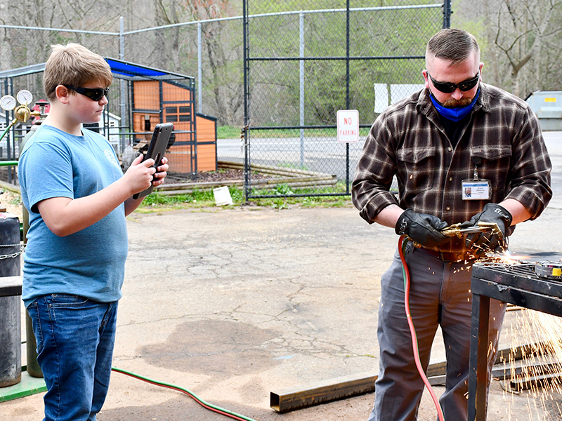 East Fannin Elementary School student Morgan Bennett had the opportunity to learn more about what CTAE has to offer at Fannin County High School Friday, March 19. Here he is shown documenting welding teacher Terry Flowers as he cuts a piece of steel.