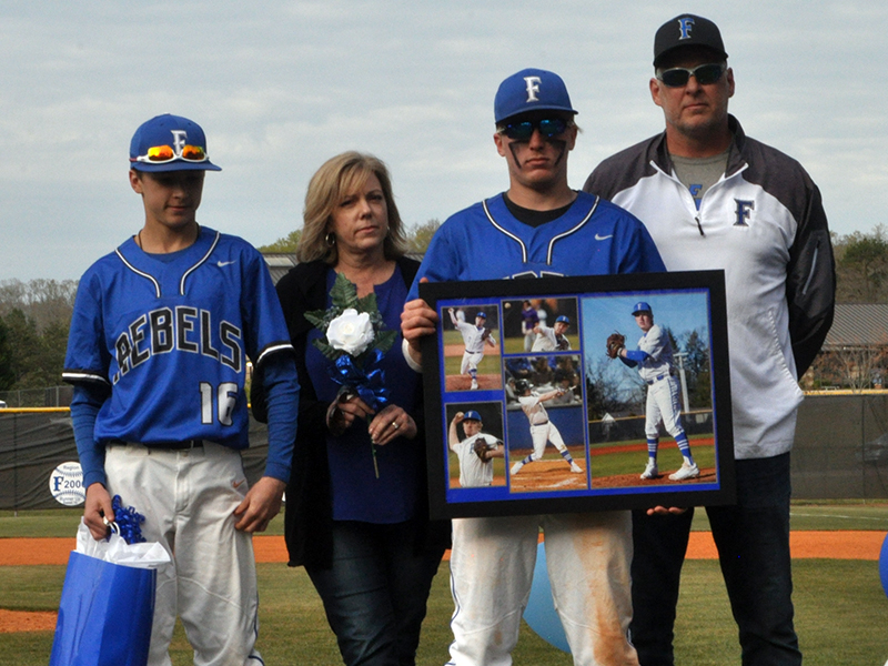Tyler Fox was one of seven Fannin County seniors honored in between games at the Rebels double header against Chattooga Friday, April 23. Shown are from left, Carter Fox, brother; Dianne Fox, mother; Fox; and Todd Fox, father.