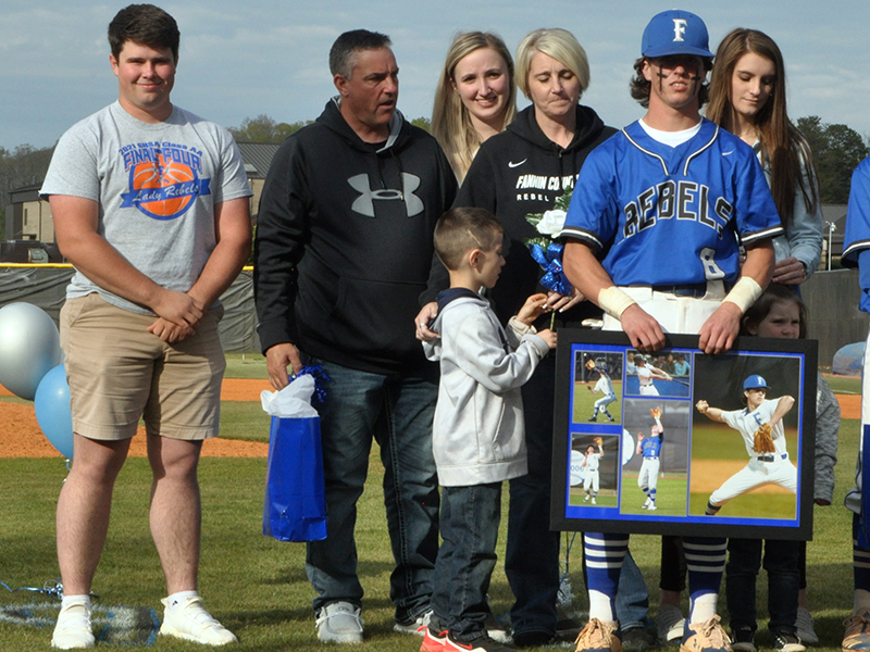 Caleb Postell was one of seven Fannin County seniors honored in between games at the Rebels double header against Chattooga Friday, April 23. Shown are from left front, Michael Postell, brother; Postell; middle, Matthew Postell, brother; John Postell, father; Stacy Postell, mother; Anna Postell, sister; Kaylin Postell, sister; and back, Kendall Postell, sister.