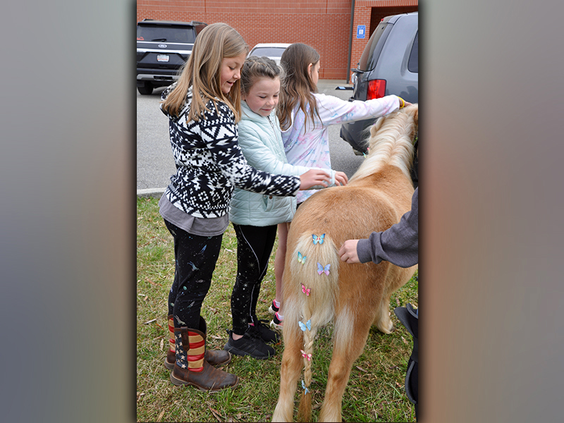 East Fannin Elementary School third grade students Melanie Padgett, left, and Sophie Price pet a pony during the Fannin County High School FFA Chapter’s Ag Day.