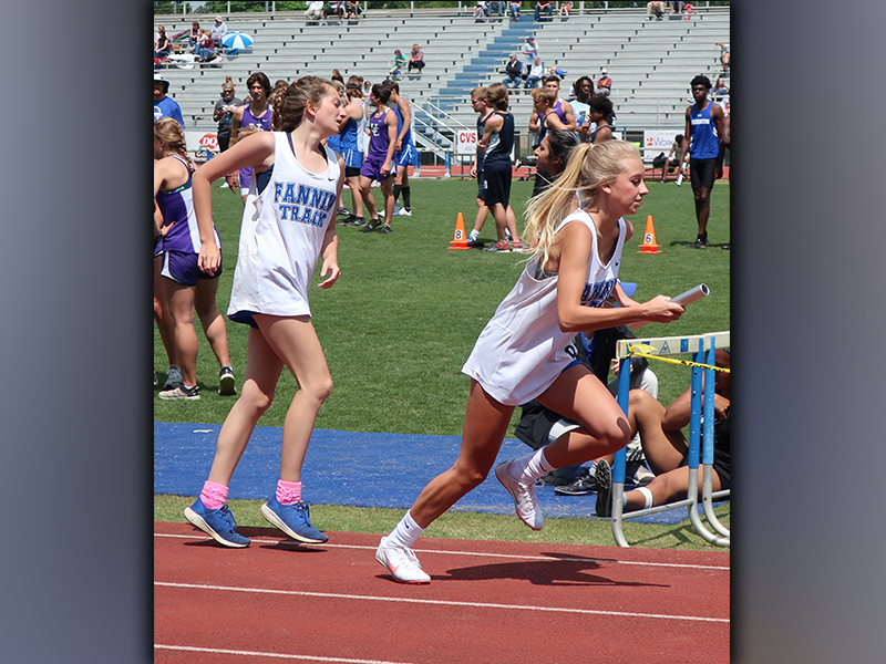Katie Thurman, left, third leg of the 4x800 Meter Relay team, passes the baton to anchor Carlee Holloway. The Lady Rebels 4x800 Meter Relay improved their time from Regions,12:09.23 to 11:59.22, to place eighth and advance to the state meet.