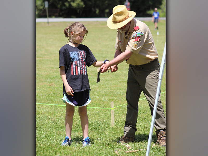 Boy Scouts of America Troop 32 Scoutmaster David Lewis instructs Morgan Kuykendall on how to perform the hatchet toss at Troop 32's Highland Games Saturday, May 1.
