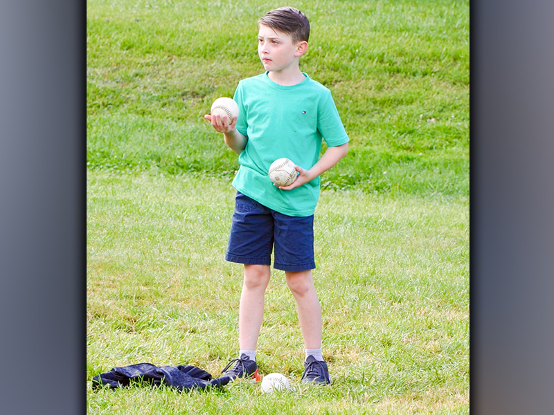 West Fannin Elementary School third-grade student Bentley Cole helps fetch balls for the tossing event during field day Thursday, May 13.