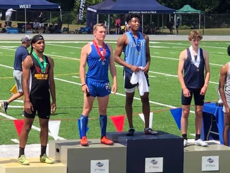 Thomas Mercer, left, shows off his medal during the ceremony at the Track and Field State Championships Saturday, May 15. Mercer finished Runner- Up in the 300 Meter Hurdles with a time of 39.84.