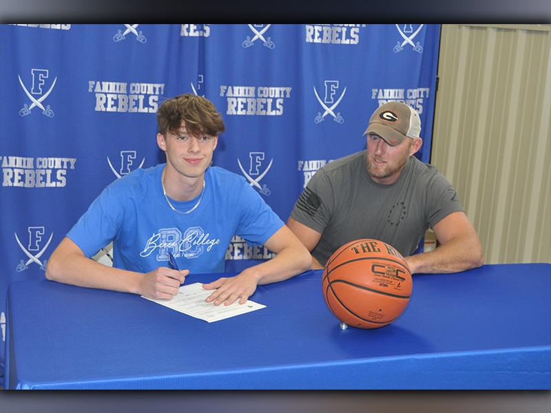 Kaeden Twiggs, left, smiles with his father Josh Twiggs after he signed his scholarship to play basketball for the Berea College Mountaineers. Friends and family gathered at the Fannin Recreation Department Wednesday, May 12.