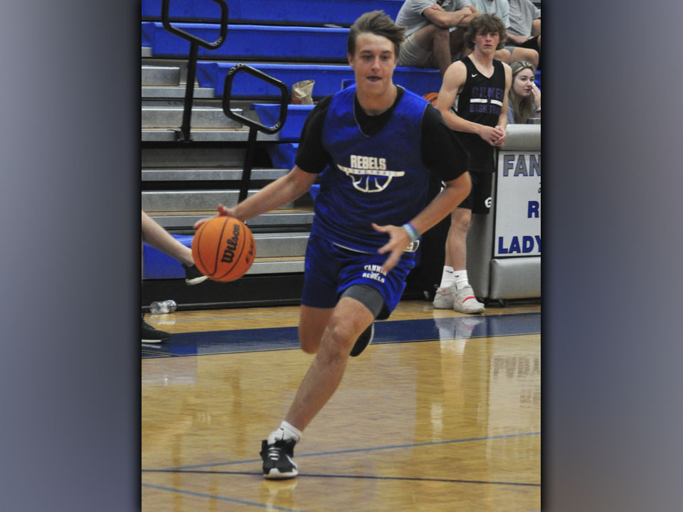 Luke Davenport edges out a defender for a score during the Rebels basketball scrimmage with Gilmer County Bobcats.