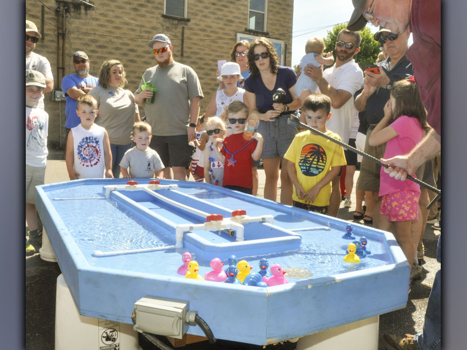 Kids and parents gather around the water race track during one of the rubber duck races at the Miner’s Homecoming in Ducktown Saturday, June 26.