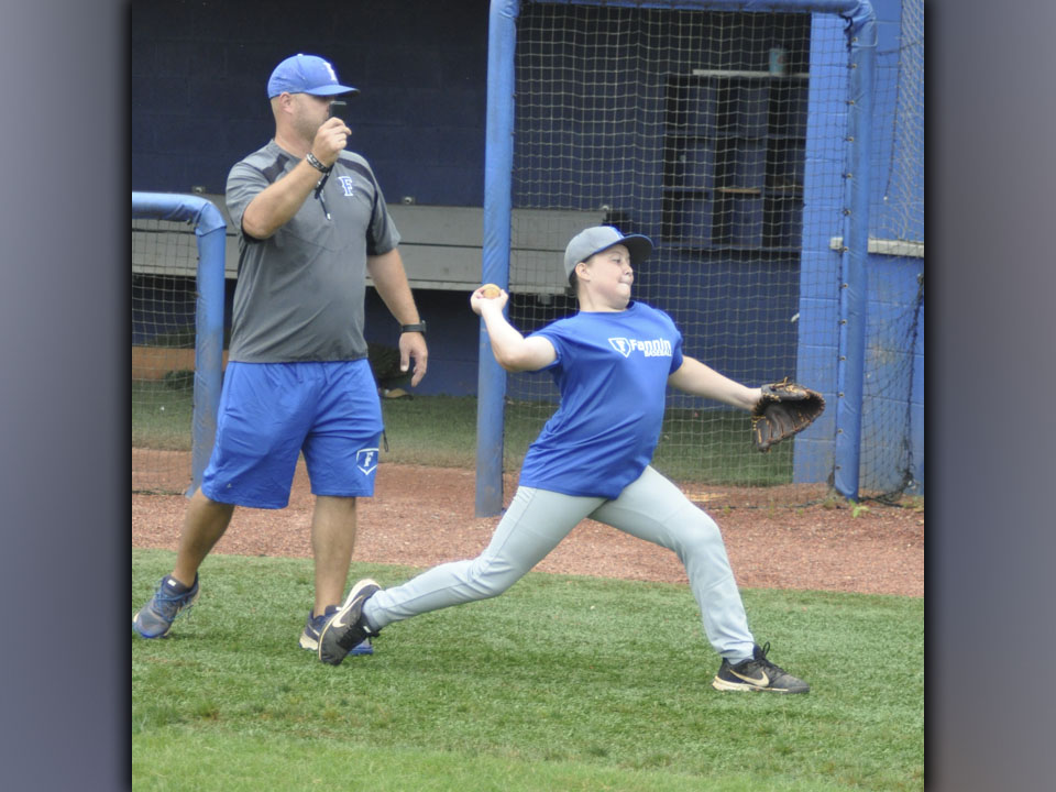 FCHS Head Baseball Coach Travis Stone times throw speed of Cayden Reece in a drill during the Pitchers and Catchers Camp Wednesday, July 7.