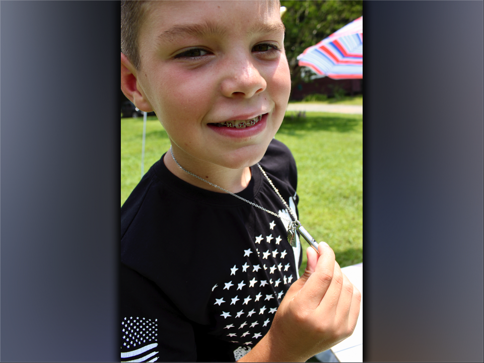Clay Maddox, age 9, of Morganton, shows his necklace. A gift from his aunt, the necklace contains the ashes of his German Shepherd, Jake, an angel wing charm and Jake’s name.