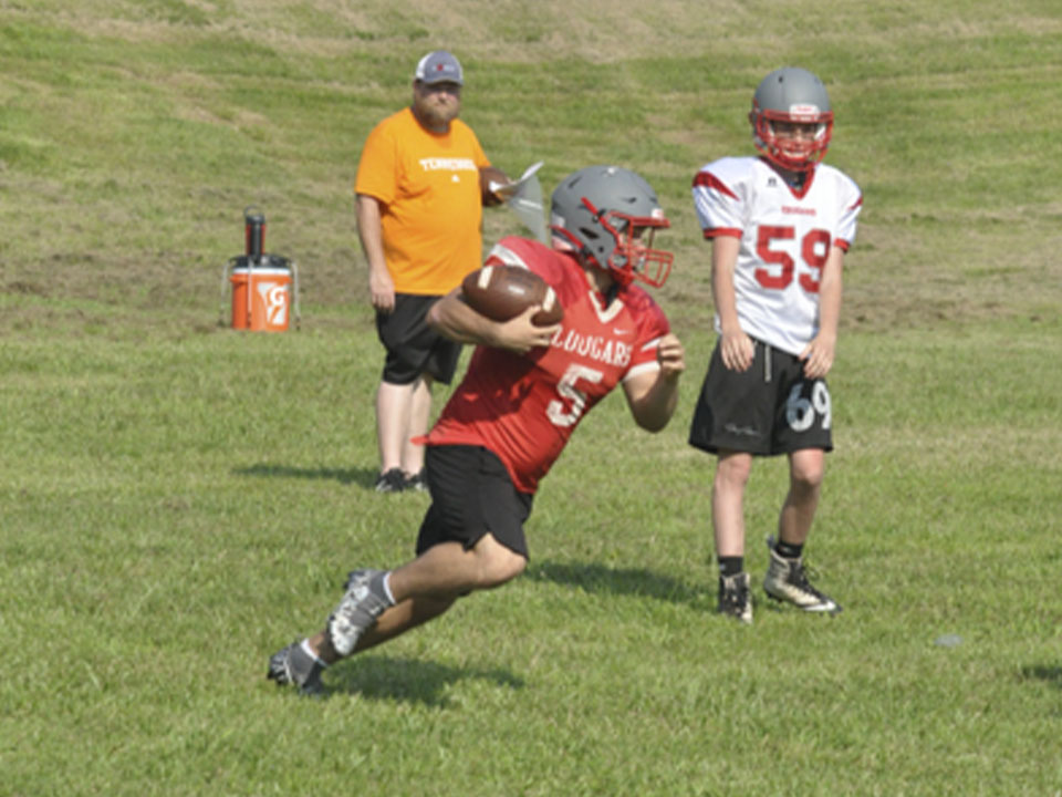 Running back Sebastian Baliles catches a toss and looks for a hole during the Cougars’ football practice Wednesday, July 28.