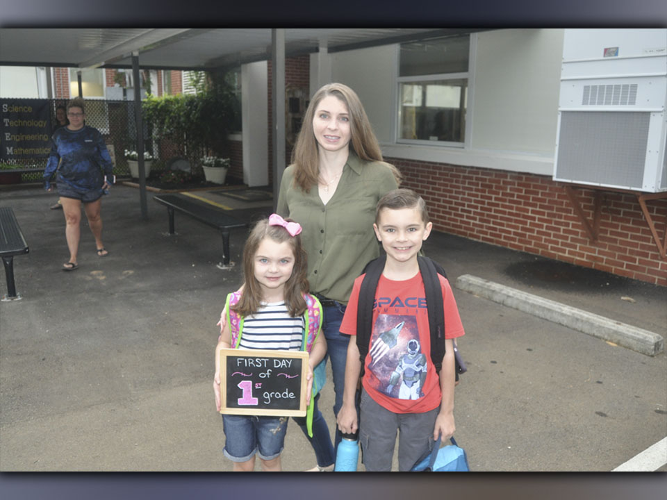 Carrie Anderson, middle, leads her kids Leia Anderson, left, and Alex Anderson into West Fannin Elementary School to start the first day of classes Friday, July 30.