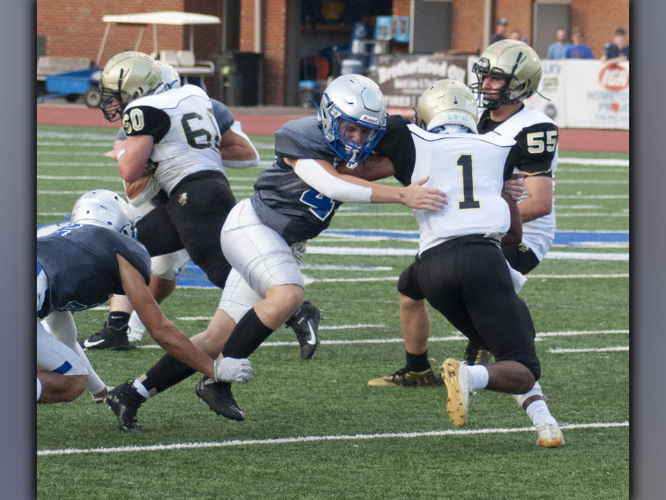 Cade Sands (49) fights through the Hayesville offensive line to bring down the Yellow Jacket quarterback during the Rebels’ scrimmage Friday, August 13. Sands had a solid game on both sides of the ball.