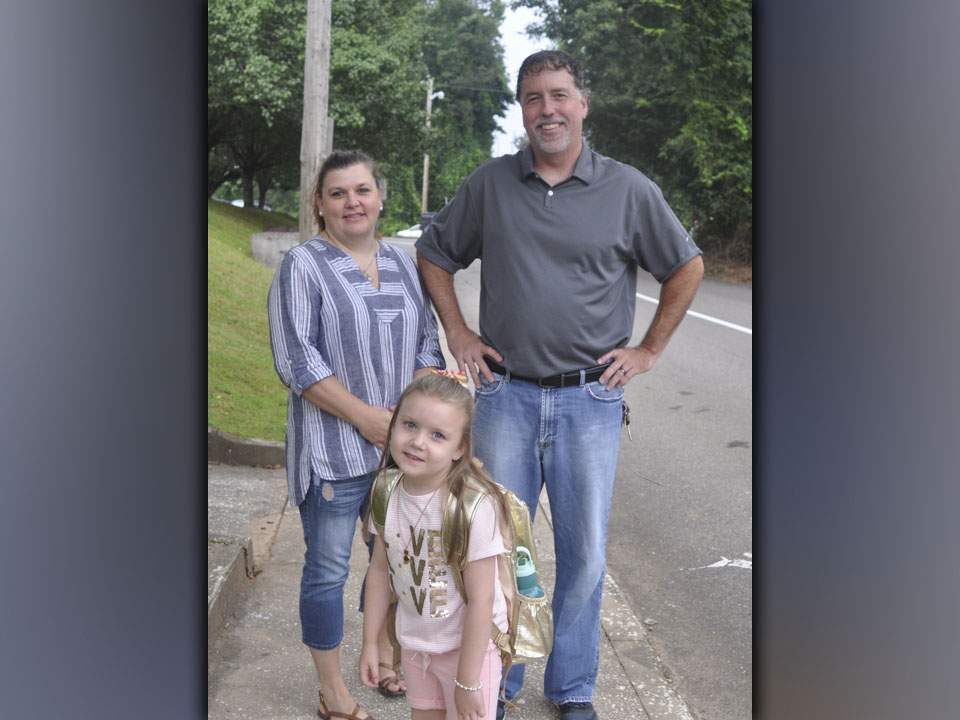 First grader Lainey Rhyne along with her parents Melissa and Richard Rhyne stop to pose for a picture on the first day of school at Blue Ridge Elementary School Friday, July 30.