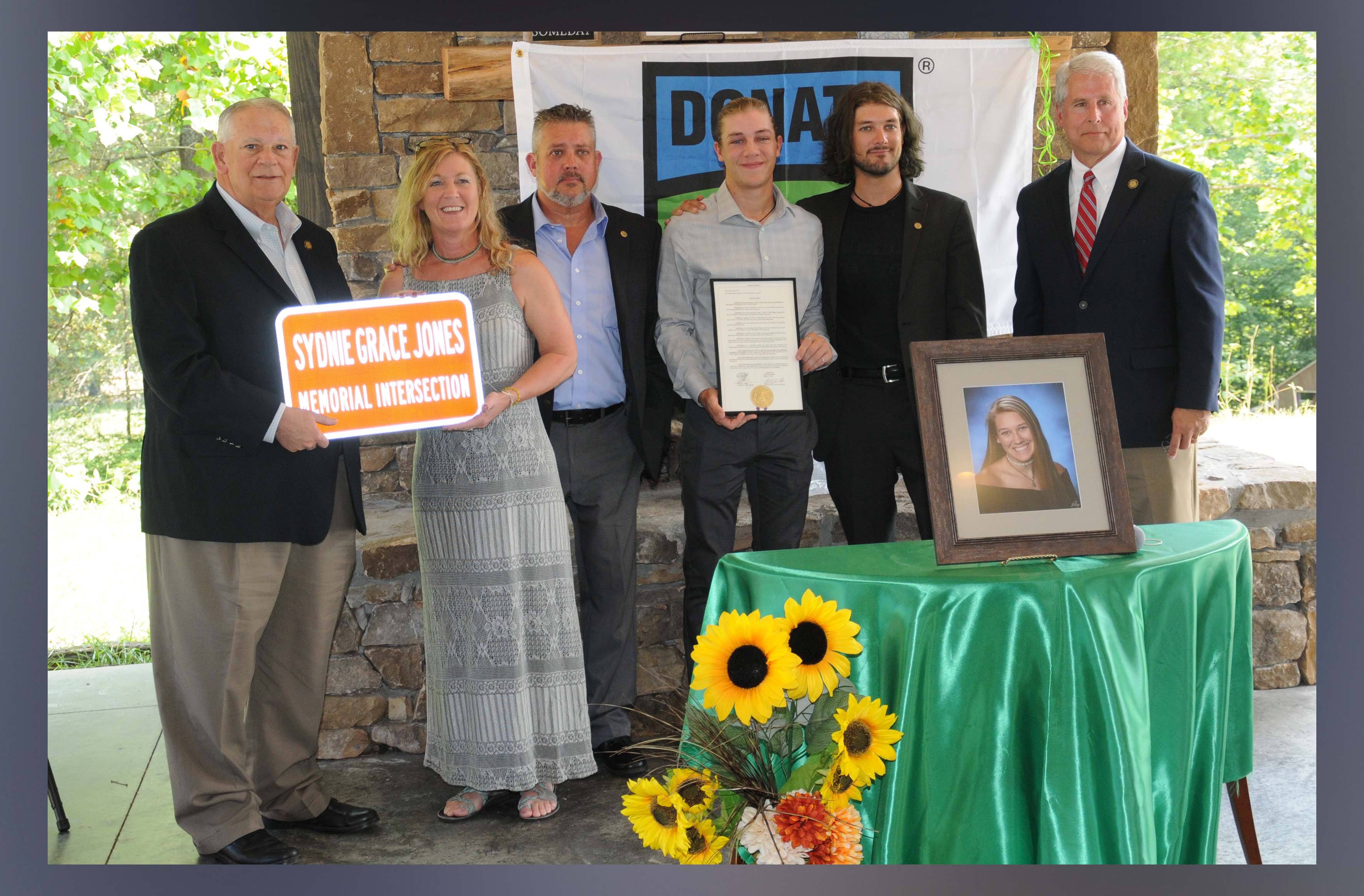 David Ralston, District 7 representative and Speaker of the Georgia House, presented replica signs to Sydnie Grace Jones’ family naming the intersection of Highways 515 and 325 in her honor. Shown, from left, are Ralston, Sydnie’s family, mother Melinda, father Anthony, brothers Andrew and Conner, and Representative Stan Gunter who co-sponsored the resolution naming the intersection.