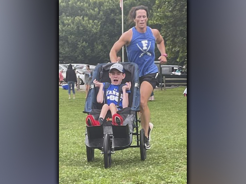 Brady Smith cries out in joy as he and his mother, Ashley Herendon, race to the finish line during a recent Fannin County High School Cross Country meet.