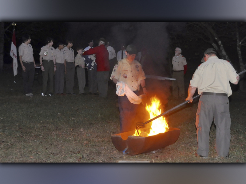 Boy Scout Roy Green of Troop 32 from Epworth places the final stripe into the fire before the final step of burning the blue field during a Flag Retirement Ceremony at Ron Henry Horseshoe Bend Park Tuesday, October 19. 
