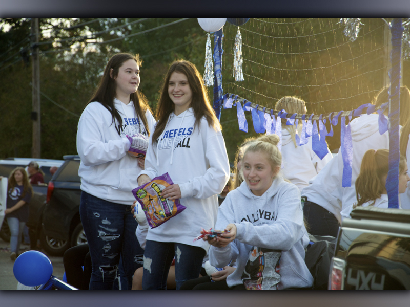 Fannin County Lady Rebels volleyball players Aubree McClure, Bailee Stiles and Ava Queen, from left, throw out candy to a crowd lined along East Main Street in Blue Ridge for a Homecoming Parade Thursday, October 21.