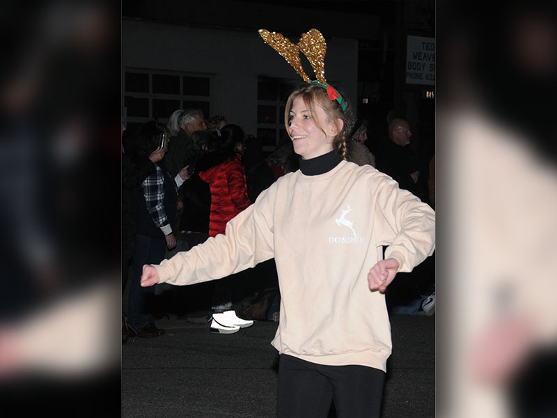 One of Santa’s reindeer dances down the street in the Light Up Blue Ridge Parade.