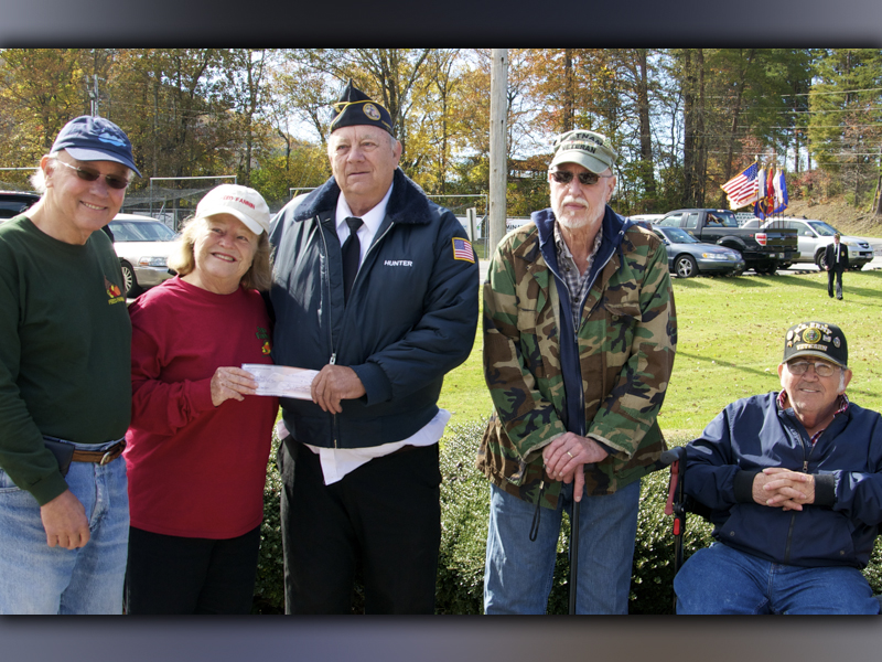 Disabled American Veterans (DAV) Chapter 28 Commander Paul Hunter hands off a check to Feed Fannin volunteer Carol Martel to help the organization purchase turkeys and hams to be distributed to those in need for the holidays. Around them are, from left, Carlos Martel, Carol Martel, Hunter, DAV Chaplin Floyd Ballance, and DAV member Charles Spivey.