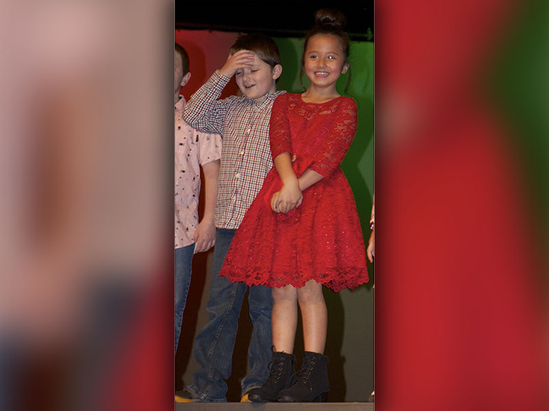 Third grade students Jameson Cloer and Sophia Ruiz, from left, shake off some nerves before singing “Rudolph the Red Nosed Reindeer” during East Fannin Elementary School’s “A Season of Joy” performances.