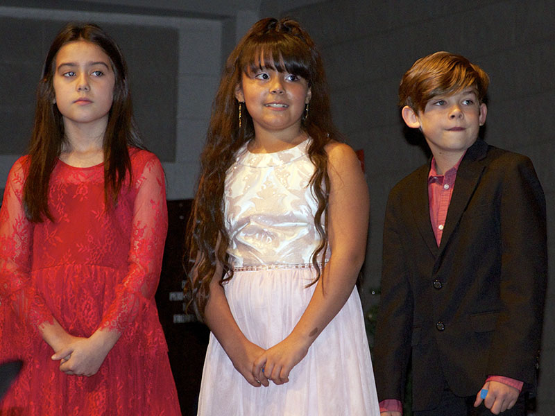 Fifth grade students McKinley Lord, Lilliana Riuz and Adam King line up for their individual solo performances during East Fannin Elementary School’s “A Season of Joy” production.