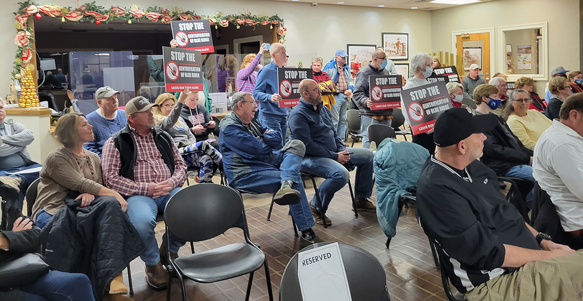 Around 10 individuals who attended the City of Blue Ridge’s Tuesday, December 21, council meeting held up these signs, showing their opposition to the proposed 60-foot condominium development on West First Street. The signs read, “Stop the gentrification of Blue Ridge. Leave our town alone.”