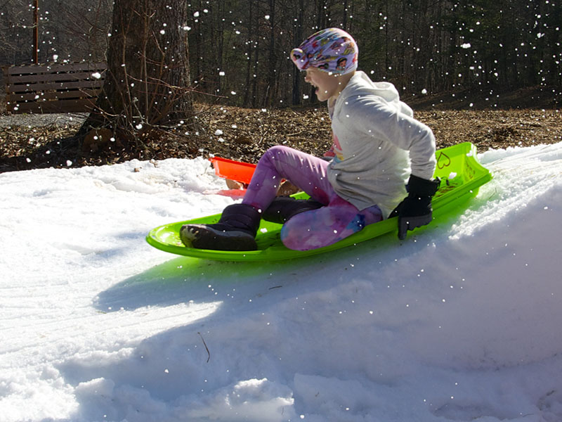 Aubrey Hutson slides down the makeshift hill topped with snow while at their rental cabin in Copperhill.