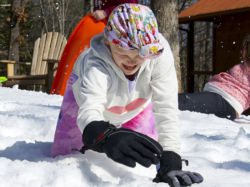 Aubrey Hutson is shown fulfilling her dream of playing in the snow while at a rental cabin in Copperhill that was donated.