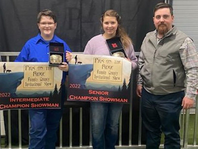 Shown are competitors Roy Green and Meah Hobbs with Kam Childers, judge of the market hog show, to their right.