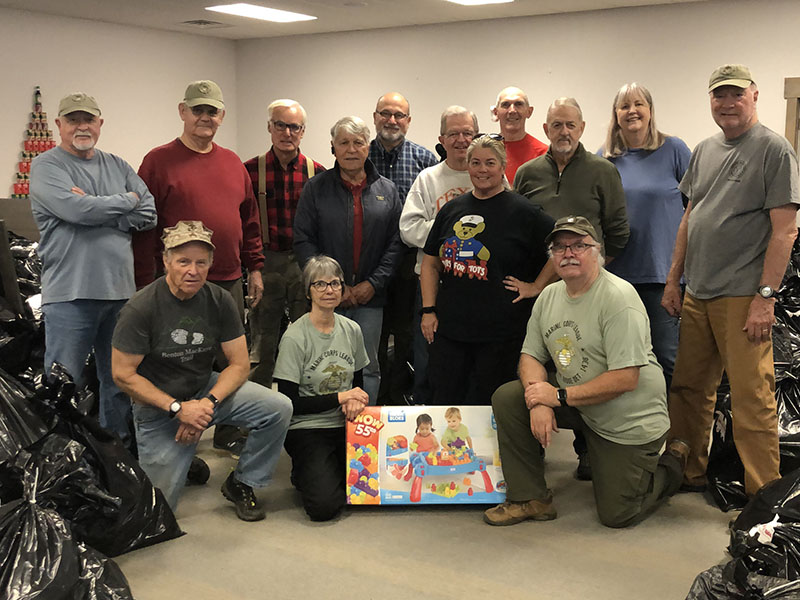 Surrounded by bags of toys that were distributed during the 2021 Toys for Tots program are volunteers, from left, front, Andy Meeks, Sherri Roberts and Bruce Van Do Gohn; back, Thom Potito, Ron Wilkander, Dick Evelyn, Joel Warner, Erik Youngberg, Jim Brumbelow, Coordinator Cheryl Jordan, Ian Guttridge, Chuck Clark, Gale Mancuso and Dale Greene.