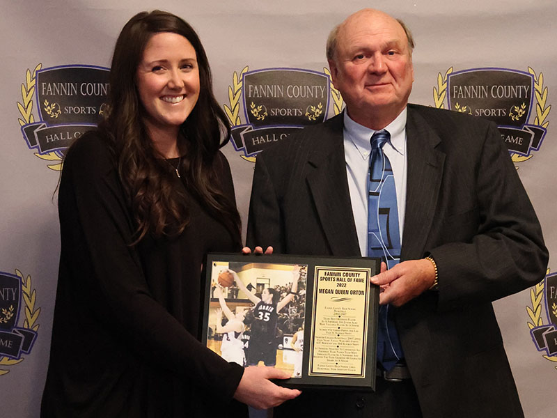 Inductee Megan Queen Orton, left, receives her plaque from Coach Johnny Farmer, right, at the Sports Hall of Fame ceremony April 9.
