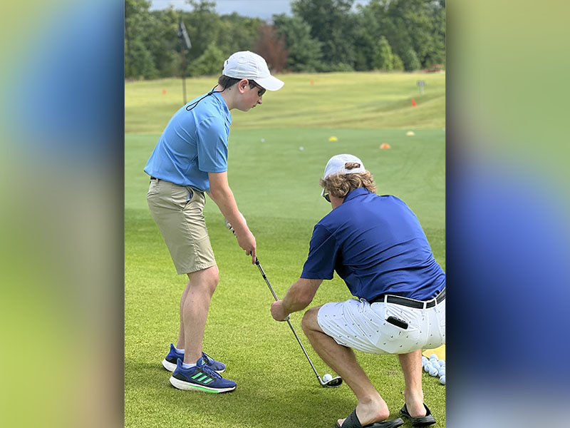 Special Olympic Athlete Alex Hughes, left, lines up his shot with the help of Steve Demboski, right, at the Special Olympics golf event Tuesday, July 19 at Old Toccoa Farm. Hughes ended the day in first place with the top score.