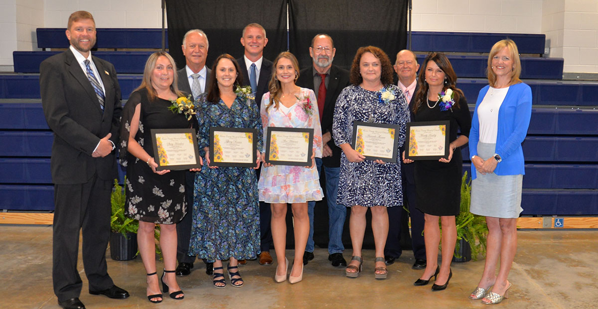 Fannin County Teachers of the Year for their respective schools are shown with school board members and school officials. From left, front are School Superintendent Dr. Michael Gwatney, Stacy Herndon, Tiffany Brown, Alex Whitener, Amanda Thomas, Mandy Housley, and incoming School Superintendent Shannon Miller, and, back, school board members Terry Bramlett, Chad Galloway, Lewis DeWeese and Bobby Bearden.