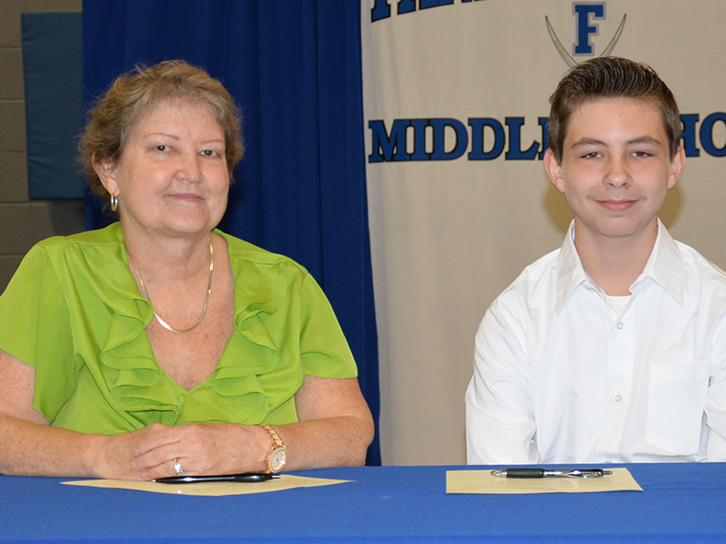 Ronald Kendall is shown with his mother, Karen Kendall, after they signed his REACH contract.