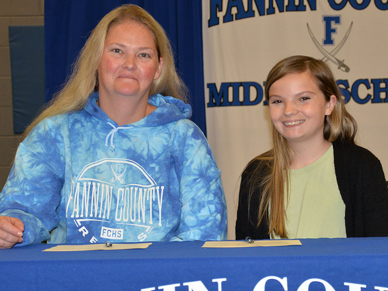 Sarah Brawley, right, is shown after she and her mother, Jessica Whitlow, signed her REACH contract.