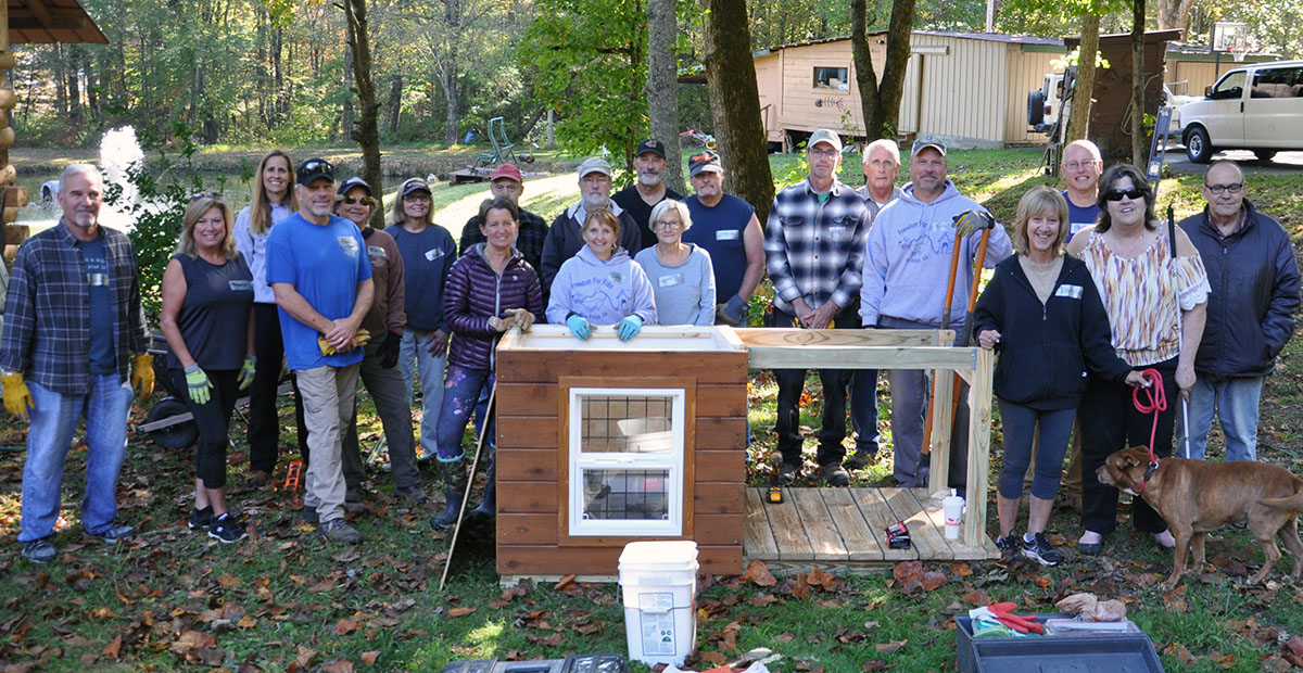 Several volunteers from Freedom for Fido, Barking Buddies, Safe Pet Project, Animal Control, and community members came out to Archie’s new home to build him a fence and a dog house. Pictured, from left, are Scott Reid, Priscilla Reid, Jen Tindle, Paul Aigner, Meri Aigner, Dana Worm, Carol Shannon, Ken Williams, Jim Williams, Jackie Gilbert, Russ Peiffer, Betty Williams, Steve Turek, Phil Peet, Tim Pauley, Jim Tindle, Donna Turek, Debi Holcomb, Archie, and David Johns.