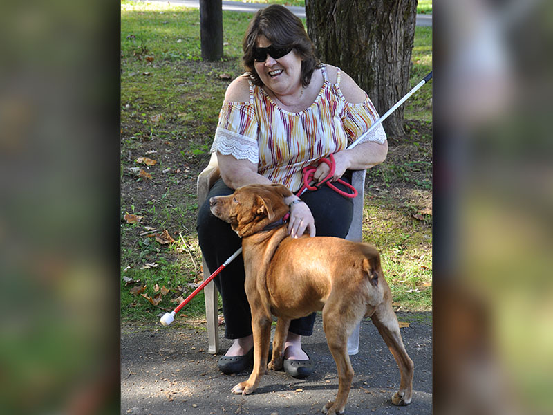 Debi Holcomb, a volunteer at the Fannin County Animal Control, is shown with Archie, who has been at the Animal Control facility for over a year. Holcomb recently adopted Archie despite several setbacks. Many volunteers gathered at her house to build Archie his very own dog house and fenced in yard.