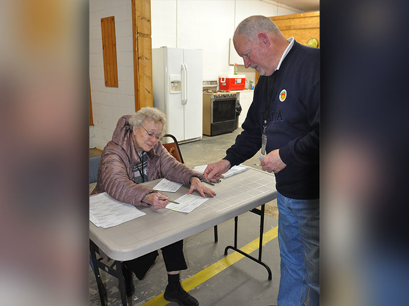 Polls were open at the Colwell voting precinct January 31, where 95 year old Anne Bailey is pictured assisting a voter.