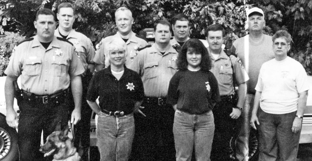 This photo shows the East Polk County staff of the sheriff’s office. The exact year could not be determined. From left are, front, dispatchers Laverne Collins, Becky Cearley, and Bobbie Waters; and standing, K-9 Deputy Sheriff Mike Mull with Bernard, Deputy Brian Fields, Chief Deputy Lew Crawford, Deputy Bill Cherry Jr., Deputy Randy Swafford, Deputy Keith Barker, and dispatcher Markie Huffman. Not pictured are deputies Weldon Boring and Brian Epperson and Detective Kevin Cole.