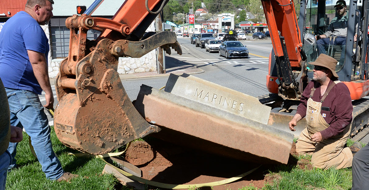 Albert Queen, Davy Ensley and Lee Dillard, from left, work to free the base of the Veterans Monument from where it has been a McCaysville landmark since 1946.