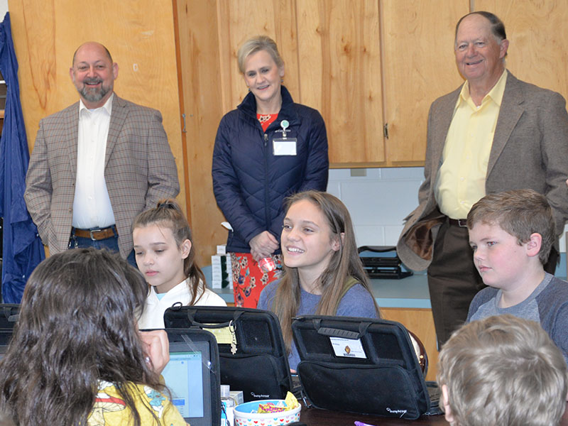 East Fannin Elementary School students Hadley Ciorrocco, Selah Patterson and Sam Hinton, seated, from left, explained the stock market to Mike Cole, Dr. Connie Huff and Bobby Bearden.