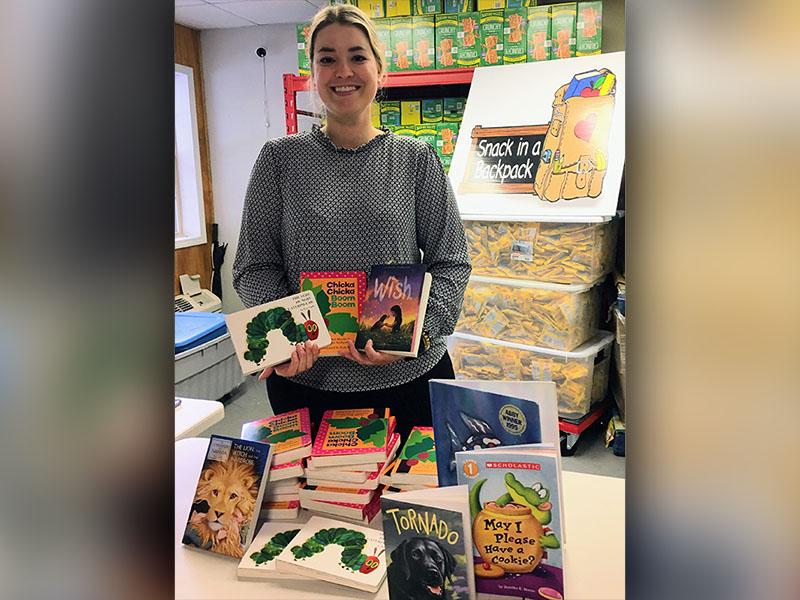 Cayley Hamilton  is shown, at the Book Dropoff 2023, unboxing the books for the Feed and Read Fannin event.