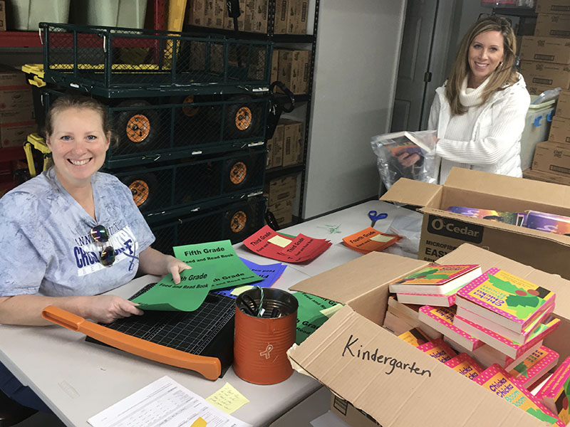 Shown are, left, Gina Farrell and Bethany Higgins, Snack in a Backpack volunteers, helping to organize and pack the books.